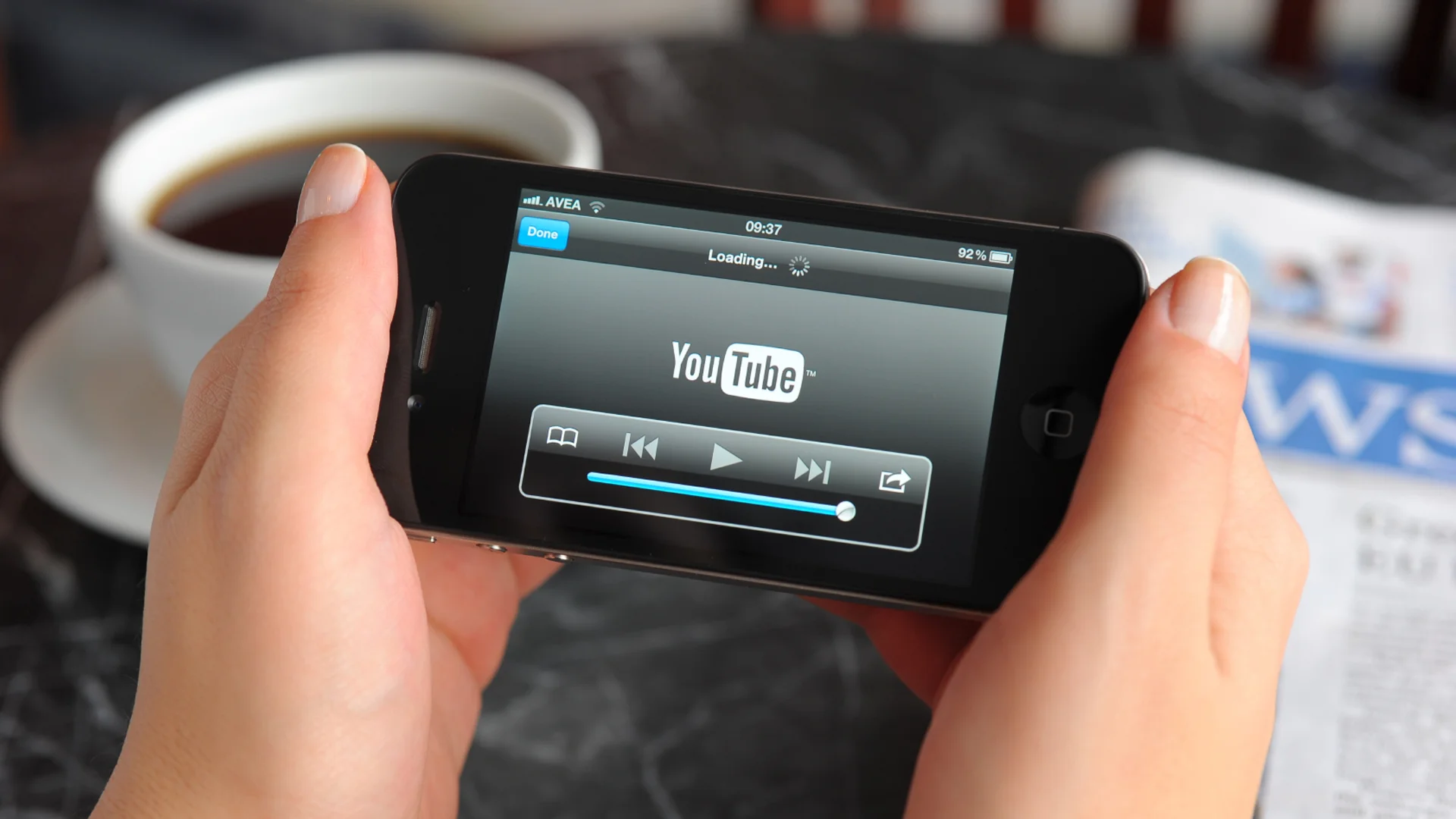 Pessoa segurando celular mexendo no youtube