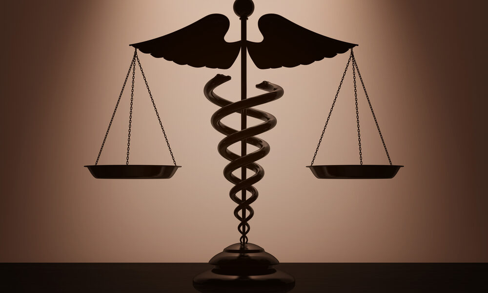 Balança de pesoas equilibrada e símbolo da medicina no meio