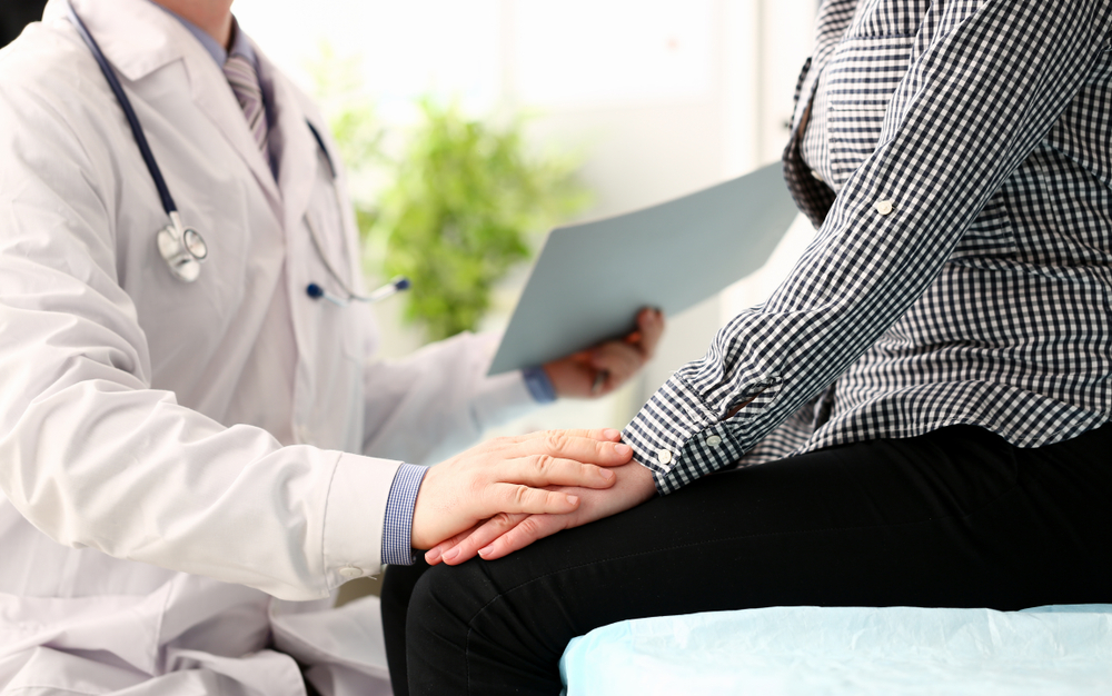 Médica segurando a mão de paciente