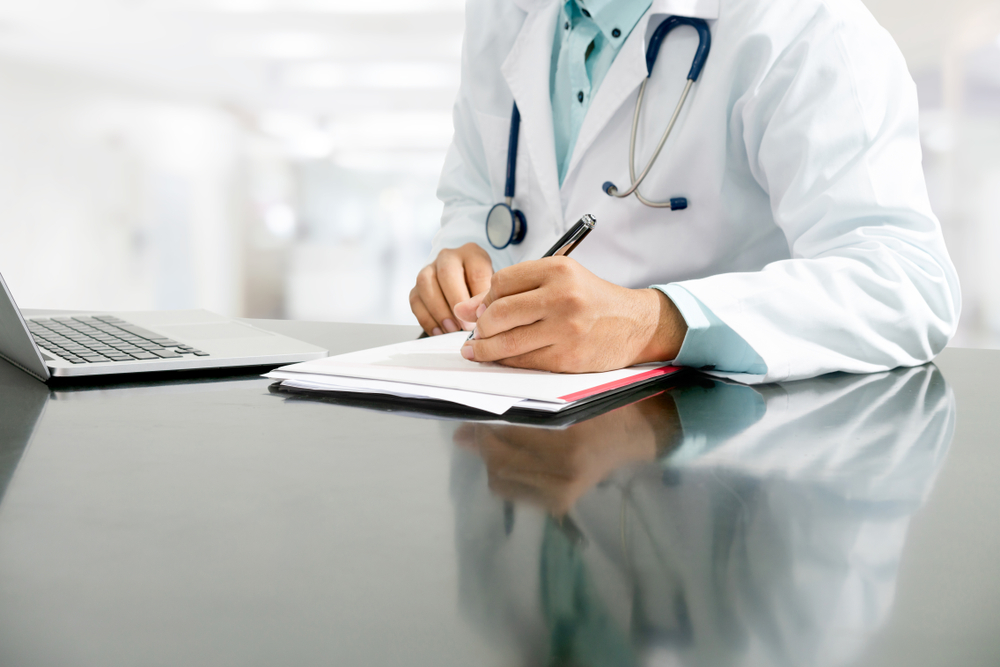 Médico mexendo em papéis de gestão de clínica médica