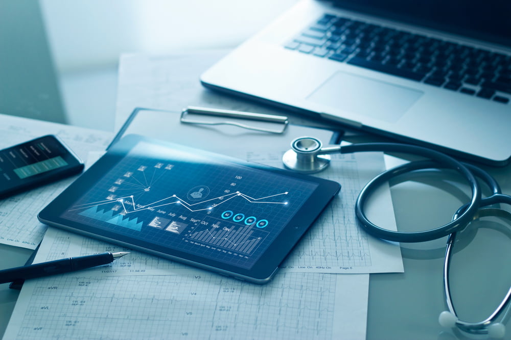 Mesa de médico com estetoscópio e tablet para analisar dados de marketing