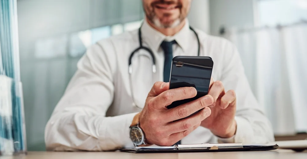 doutor navegando em redes sociais para representar as redes sociais para marketing médico