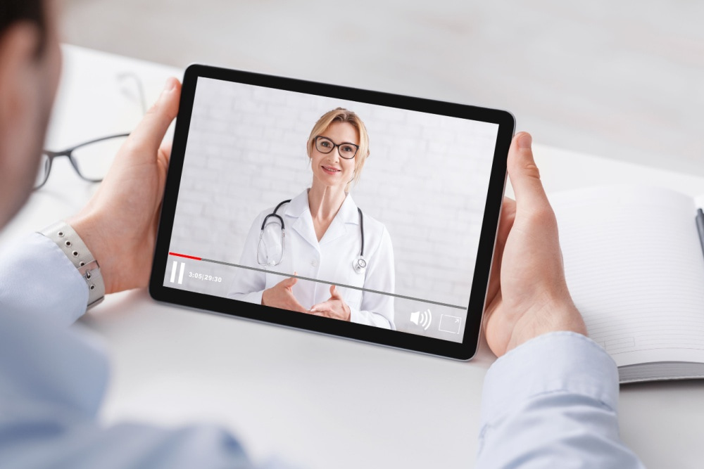 Pessoa assistindo vídeo de uma médica em seu tablet.